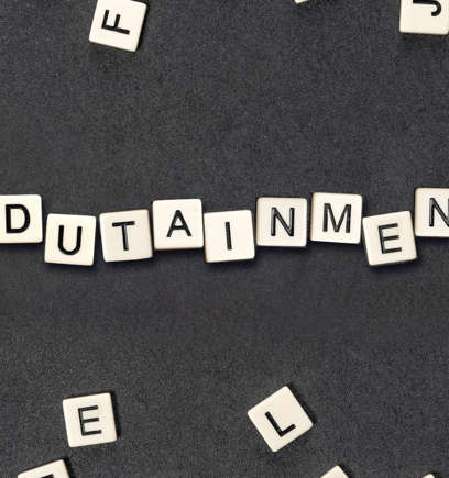 The word edutainment spelled with Scrabble letter tiles