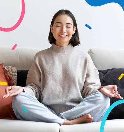 A woman meditating while smiling and sitting on her couch